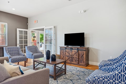 a living room with a couch and chairs and a television